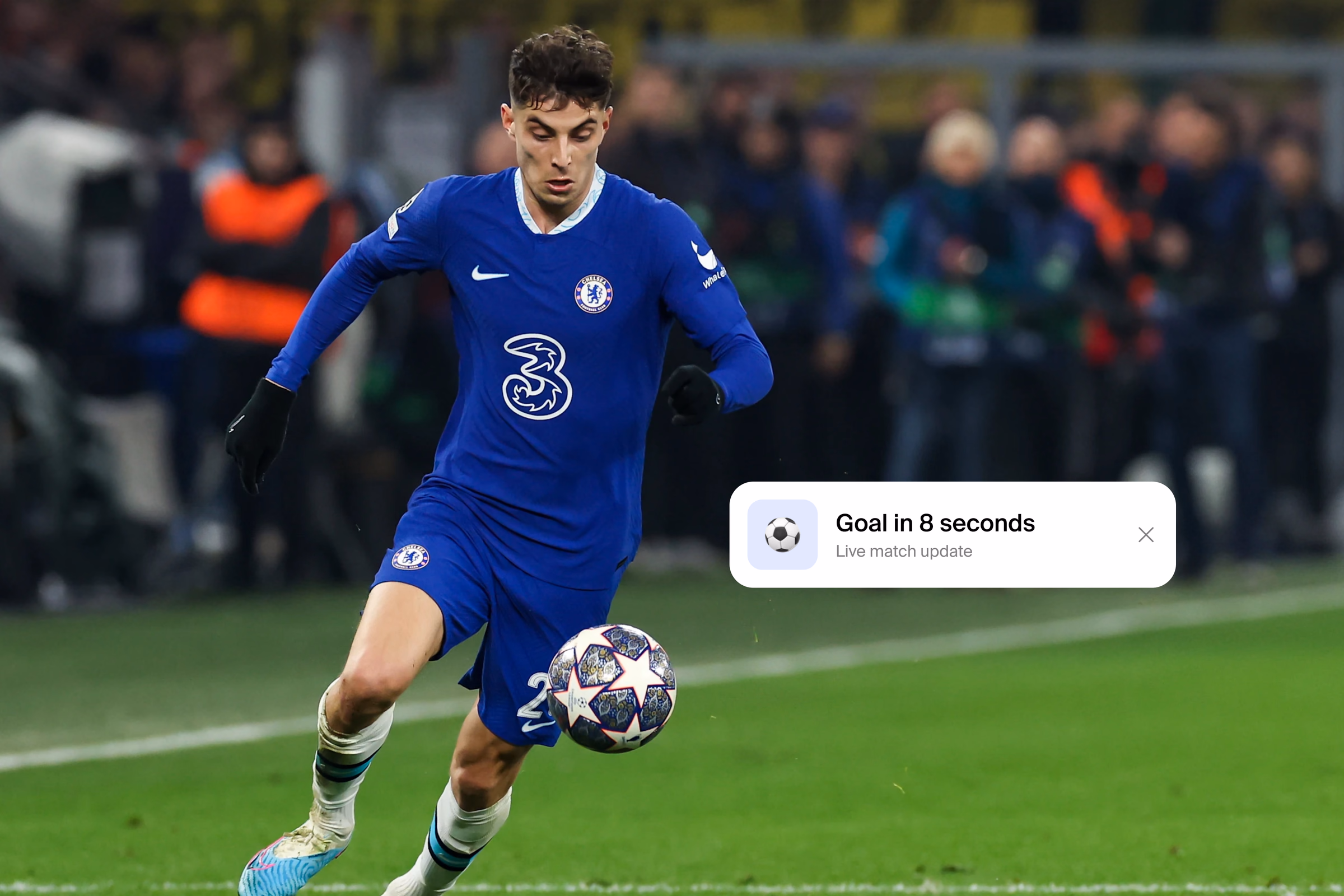 A footballer running with the ball under floodlights, with a phone notification over the pitch reading Goal in 8 seconds.