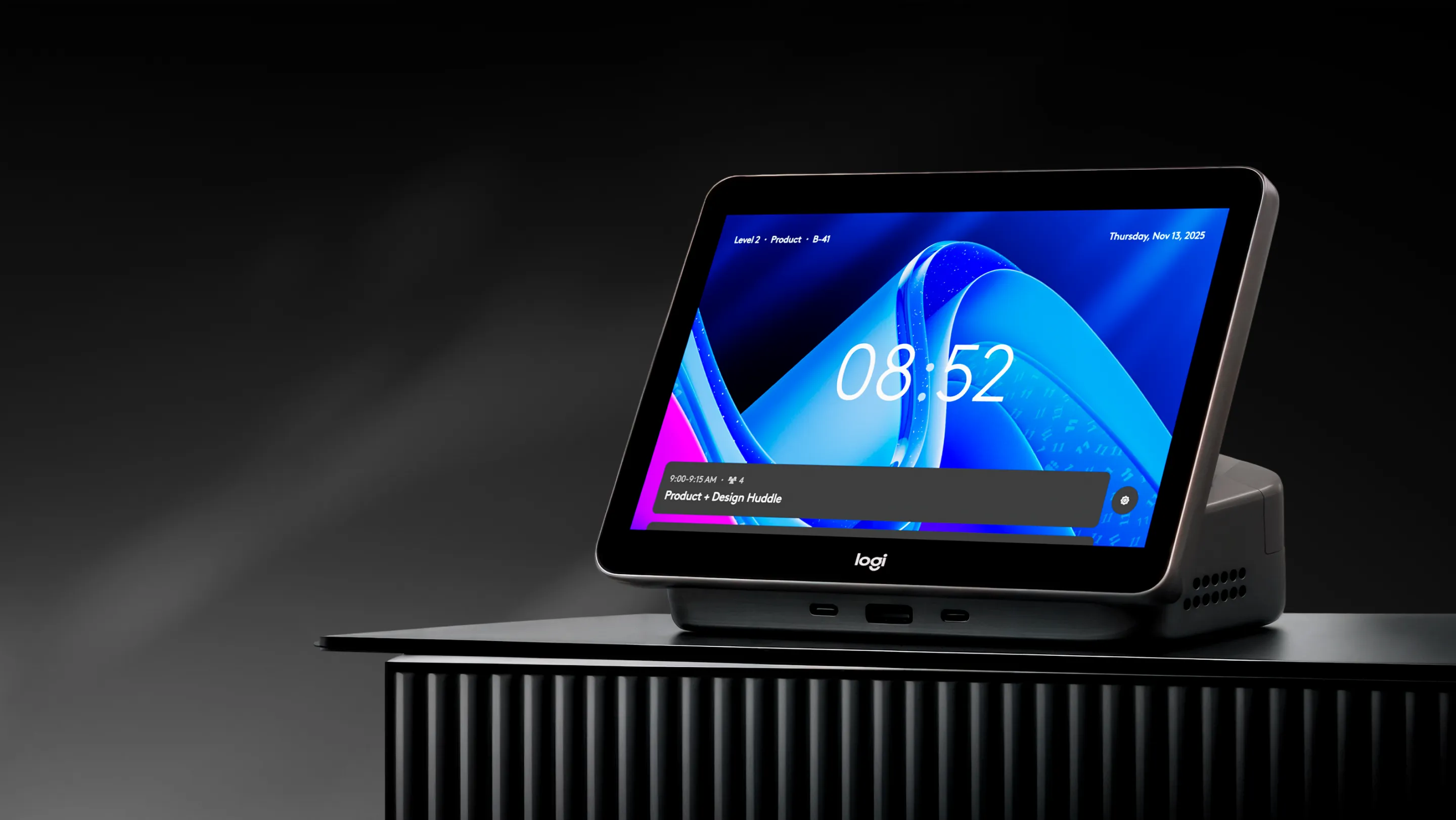 Logi Dock Flex on a dark ribbed stand showing a desk booking screen
